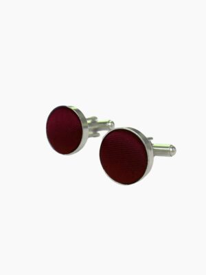 A pair of stylish apple - colored cufflinks with a shiny finish.