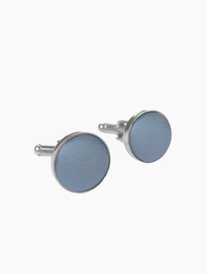 A pair of dusty blue - colored cufflinks with a metallic edge.