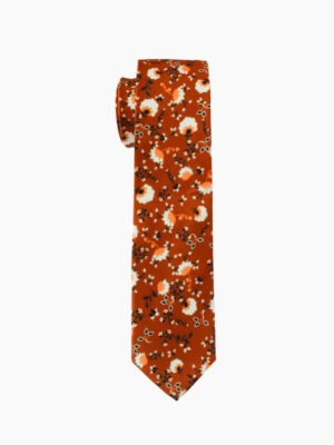 A rust - colored tie with white floral patterns.