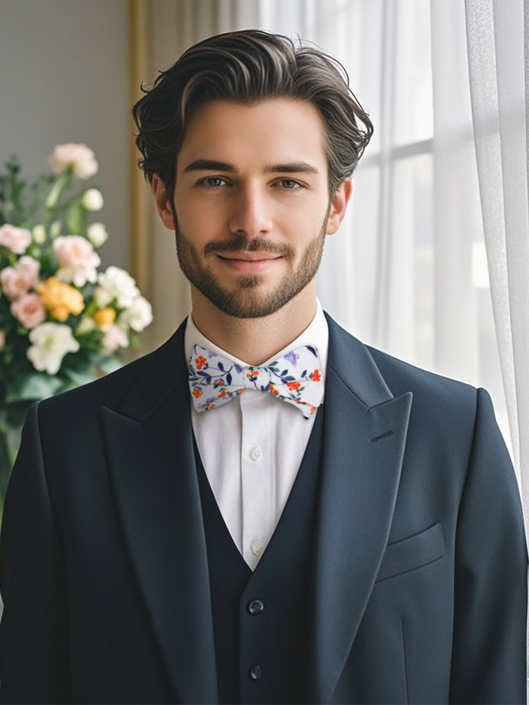 A man wearing a dark suit and a rust orange floral self - tied bow tie, exuding a bold and stylish charm.