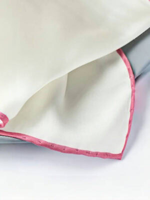 Close - up of a white silk pocket square with a hand - rolled pink (ballet - colored) border.